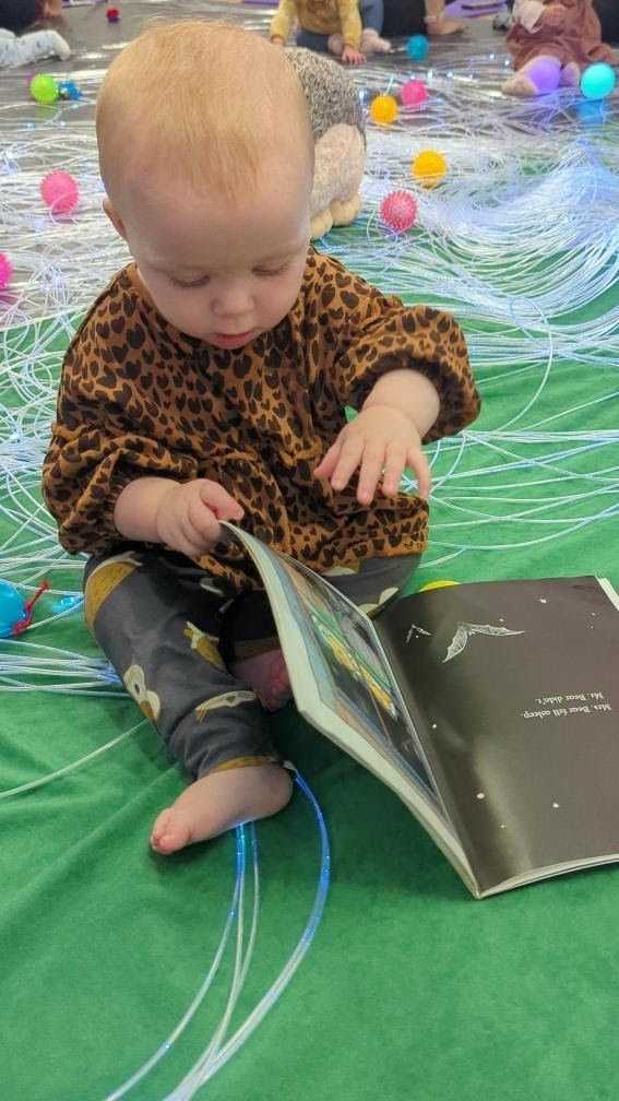 A toddler looking through a picture book