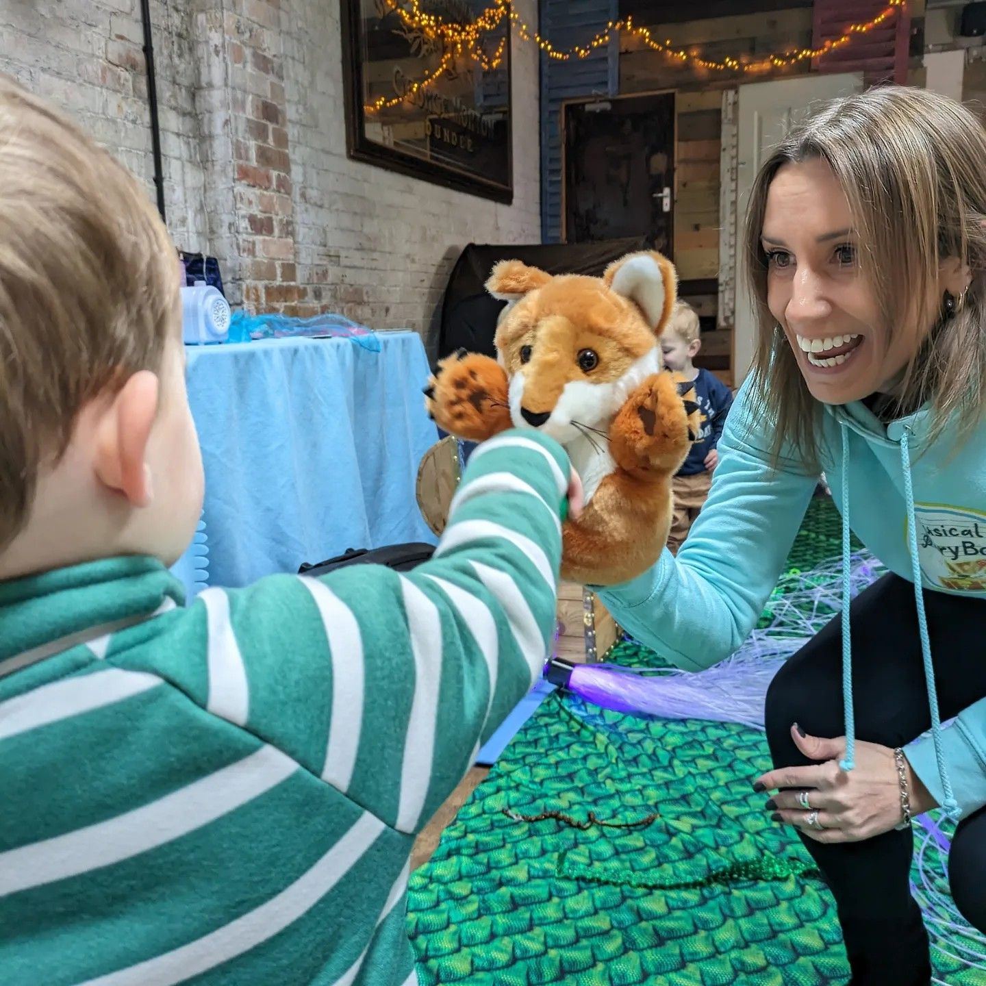 A child meeting a fox puppet in class