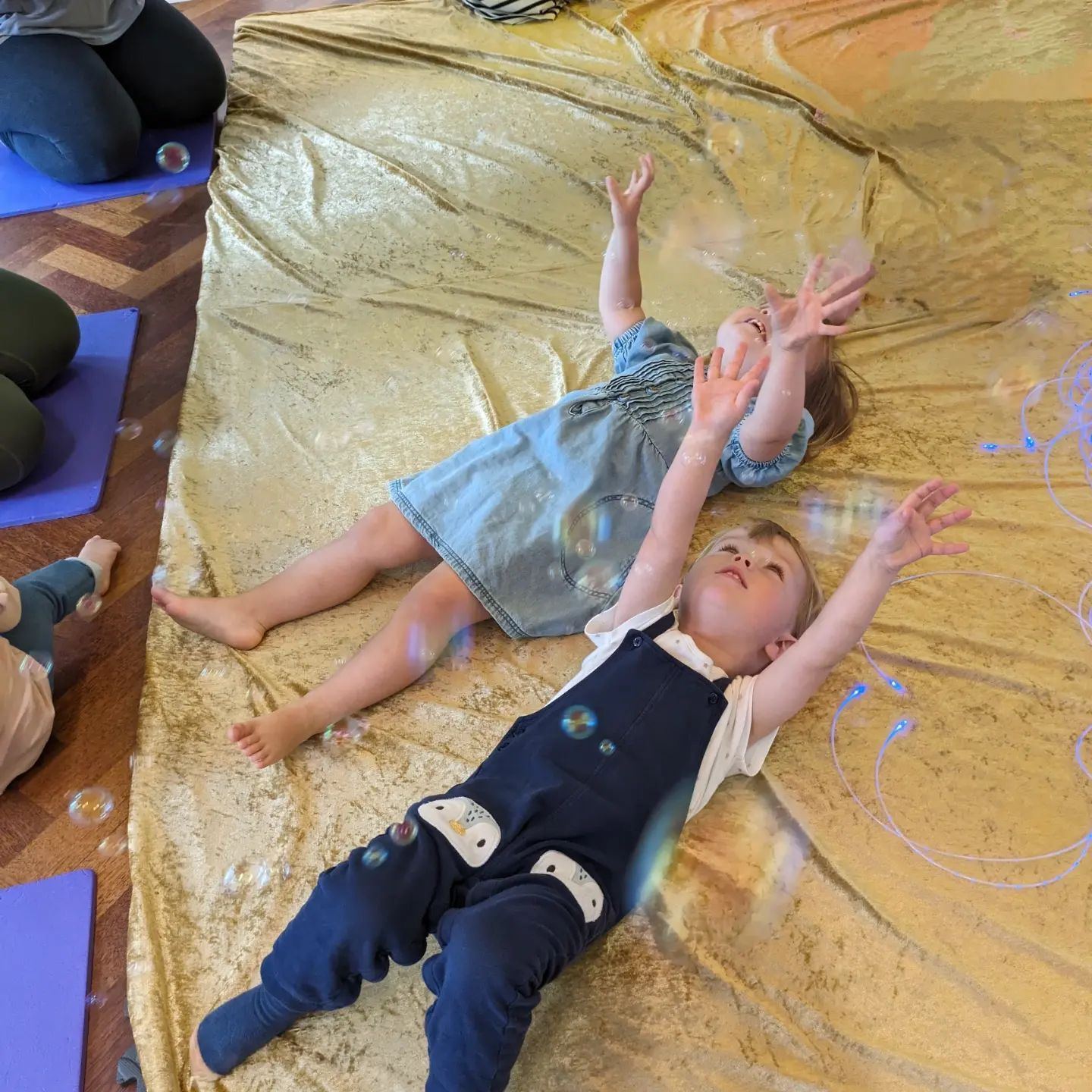 Babies playing on shimmering sensory fabric