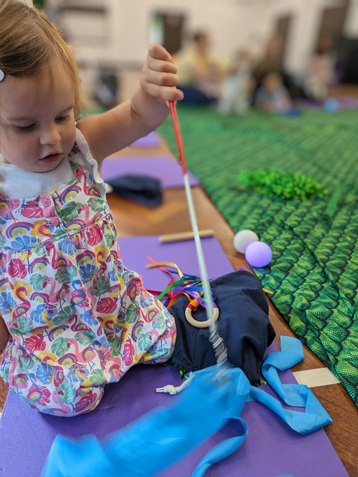 A toddler playing with sensory props
